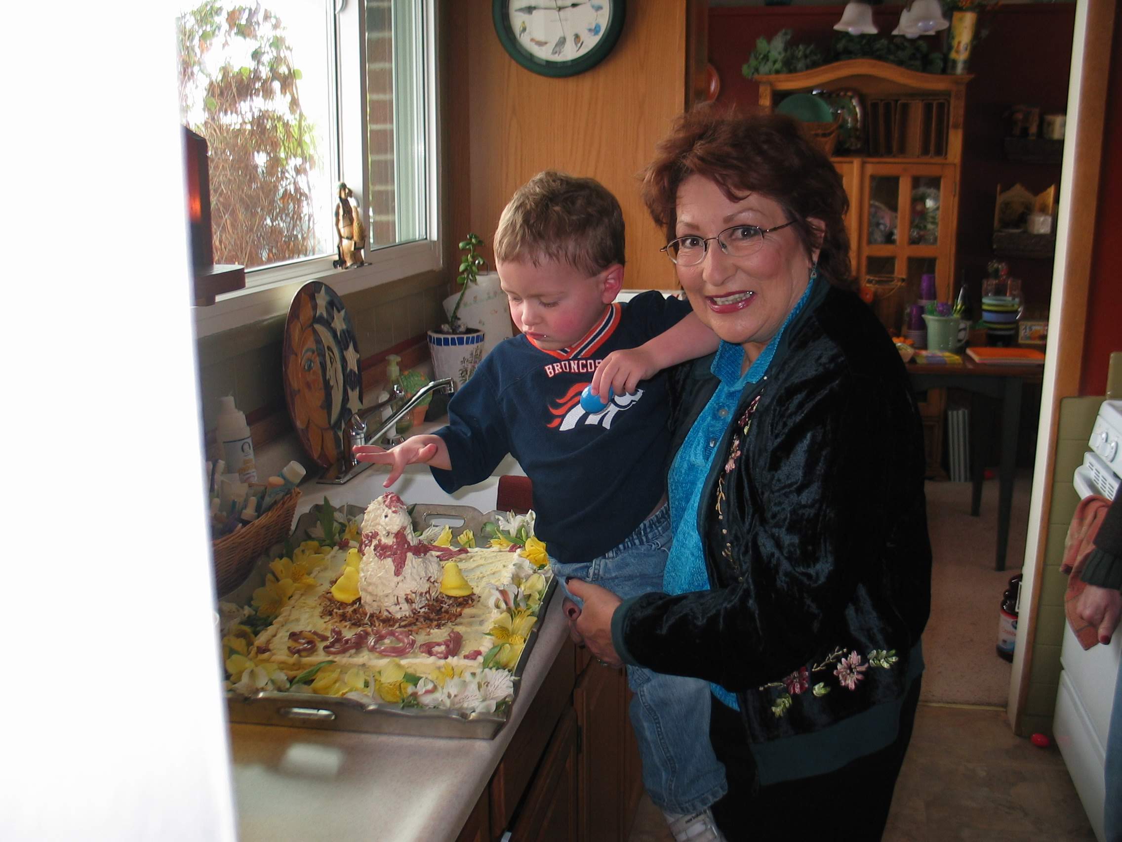 Marty and one of her famous grandkid bday cakes. She's holding Sam, Presley's paternal cousin.